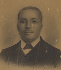African American man with a mustache wearing late 19th century attire.