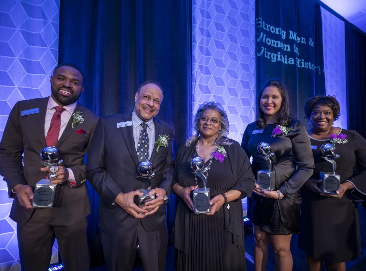 two African American men and three African American women in a row holding awards