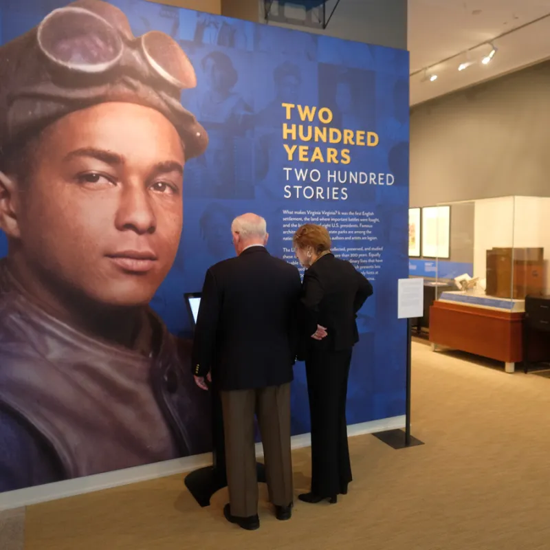Two visitors browse the 200 Years: 200 Stories exhibition at the Library