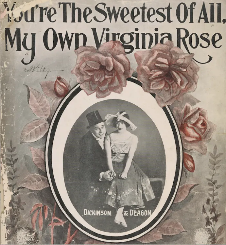 The top of the image says "You're the sweetest of all. My own Virginia rose." The middle of the image show a man and woman in clothing from the early 20th century. The man is in a tuxedo with a black top hat and the woman is in a white shirt and long skirt, with a large hat on. Their image is framed in an oval, surrounded by drawn pink roses.